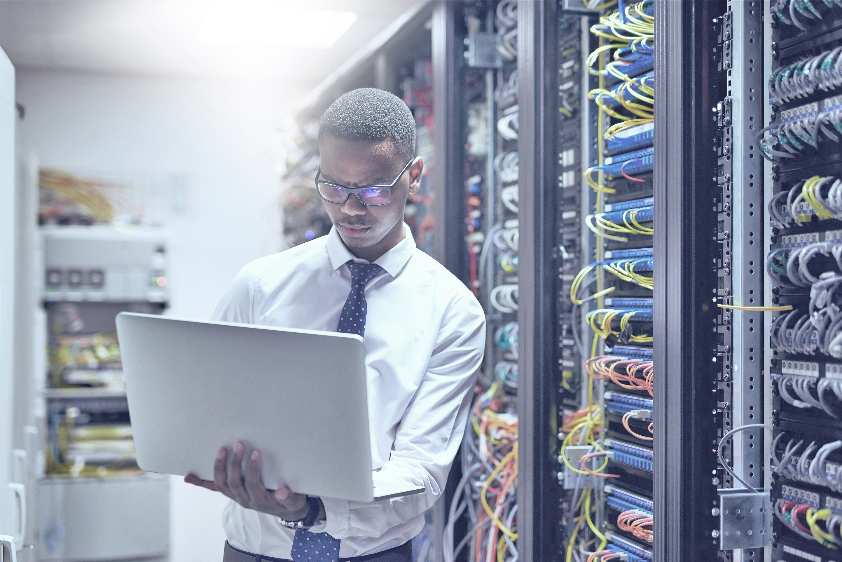Fachkräfte in Afrika | © GettyImages/anandaBGD Mann arbeitet im Server Raum