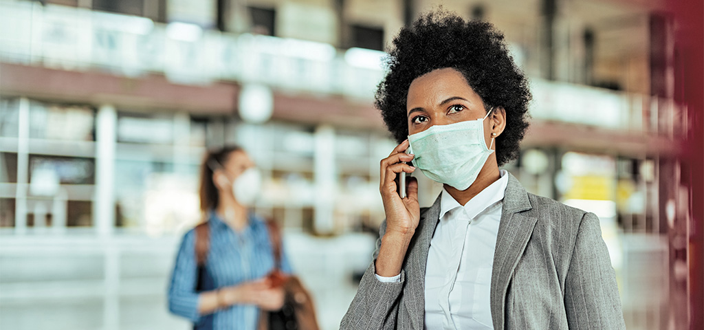 Coronavirus und die Folgen auf die Wirtschaft in Afrika | © GettyImages/Drazen Zigic Geschäftsfrau am Flughafen mit Maske während Coronapandemie