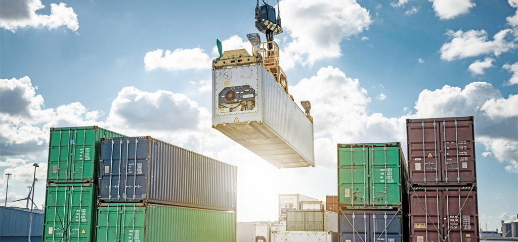 Container wird auf ein Containerschiff in Afrika verladen | © GettyImages/Jorg Greuel Kühlcontainer wird auf ein Containerschiff verladen