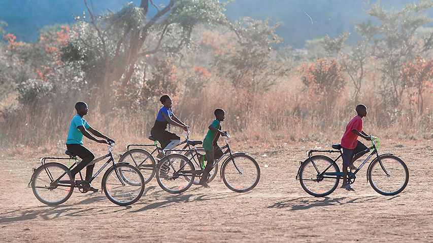 Junge Menschen auf Fahrrädern in Afrika.