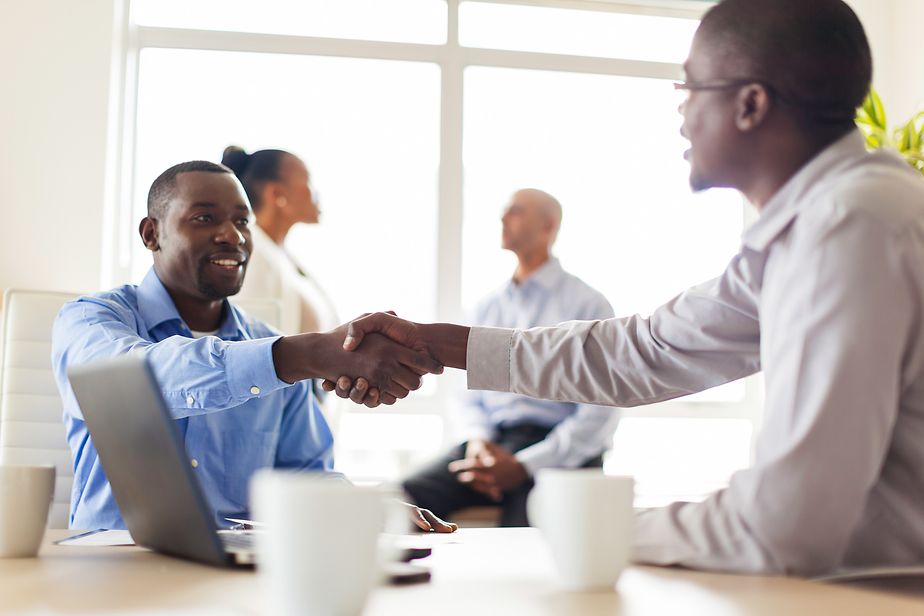 Zwei afrikanische Geschäftsmänner begrüßen sich bei einem Meeting in Kapstadt, Südafrika.