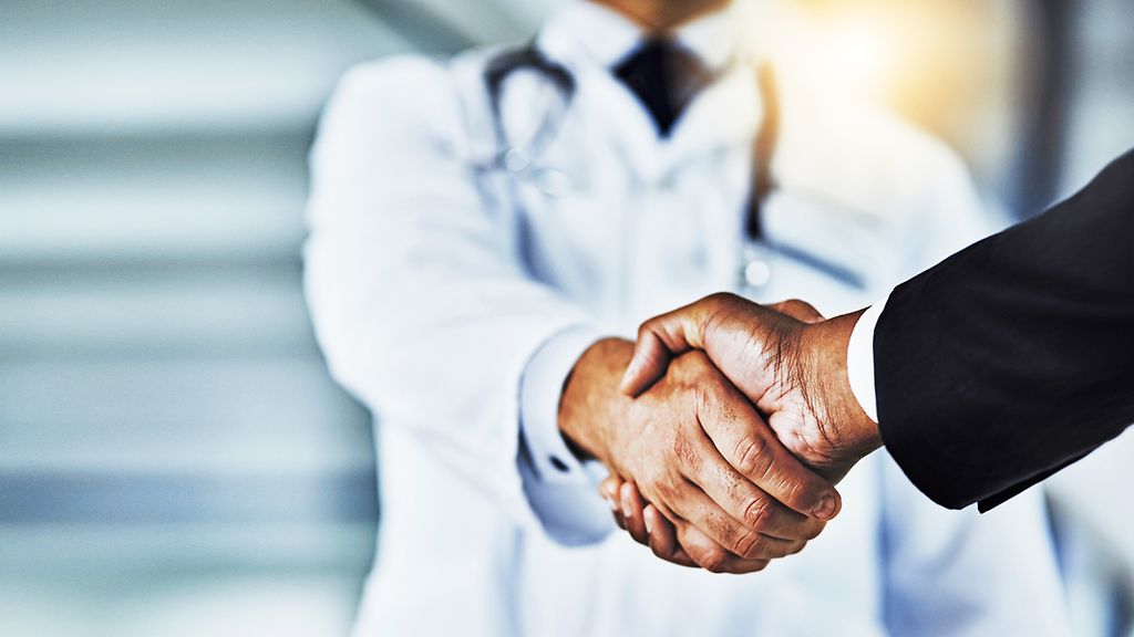 Handshake zwischen einem Arzt und einem Geschäftsmann