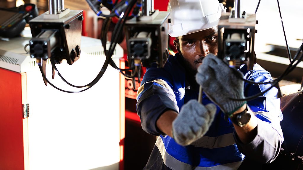 Afrikanischer Ingenieur überprüft eine Anlage in einer Maschinenbaufabrik in Afrika.ft und repariert