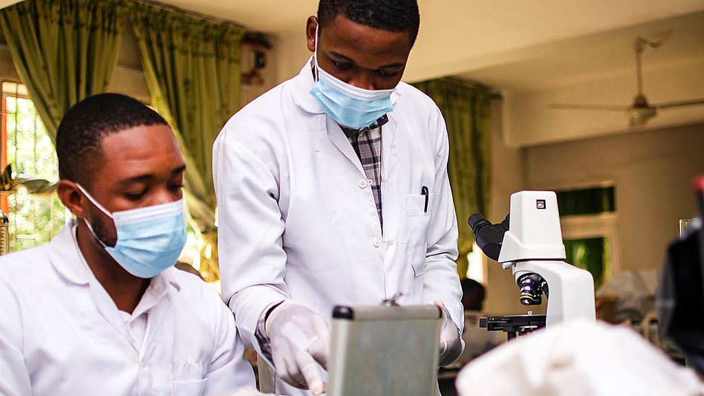 Zwei Ärzte arbeiten mit medizinischem Equipment in einem Labor in Afrika.